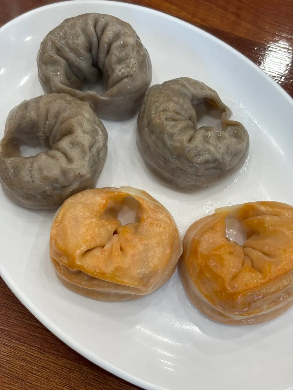 A plate of half-and-half steamed mandu with buckwheat wrappers