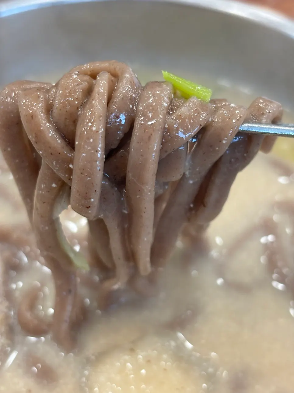 Buckwheat kalguksu noodles lifted from the perilla broth