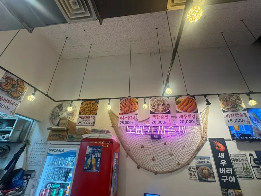메뉴 사진이 붙은 초록색 벽 실내 좌석