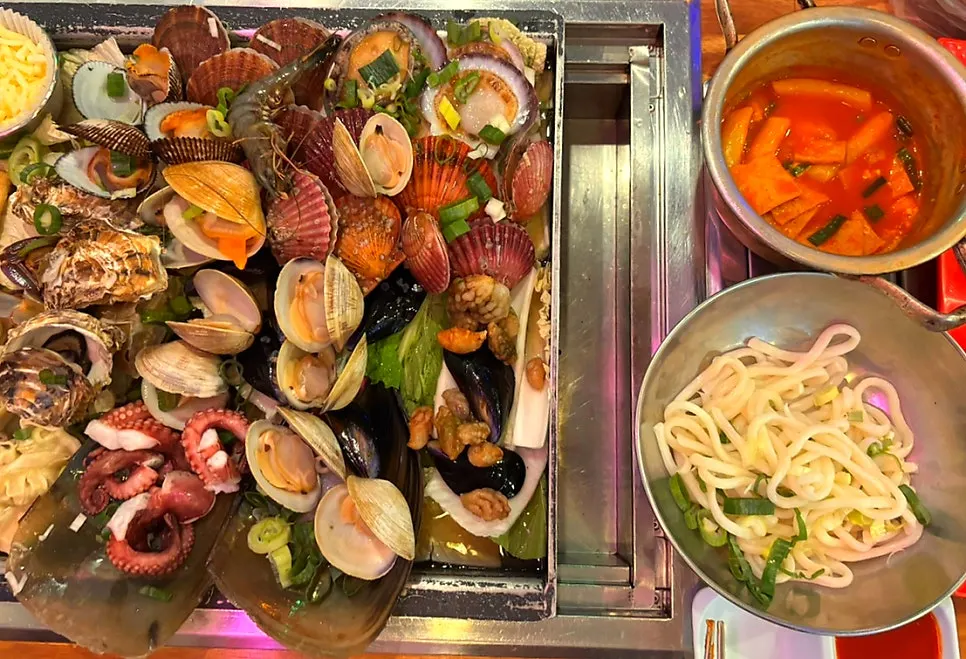 The small clam hot pot filling the griddle pan and bubbling away