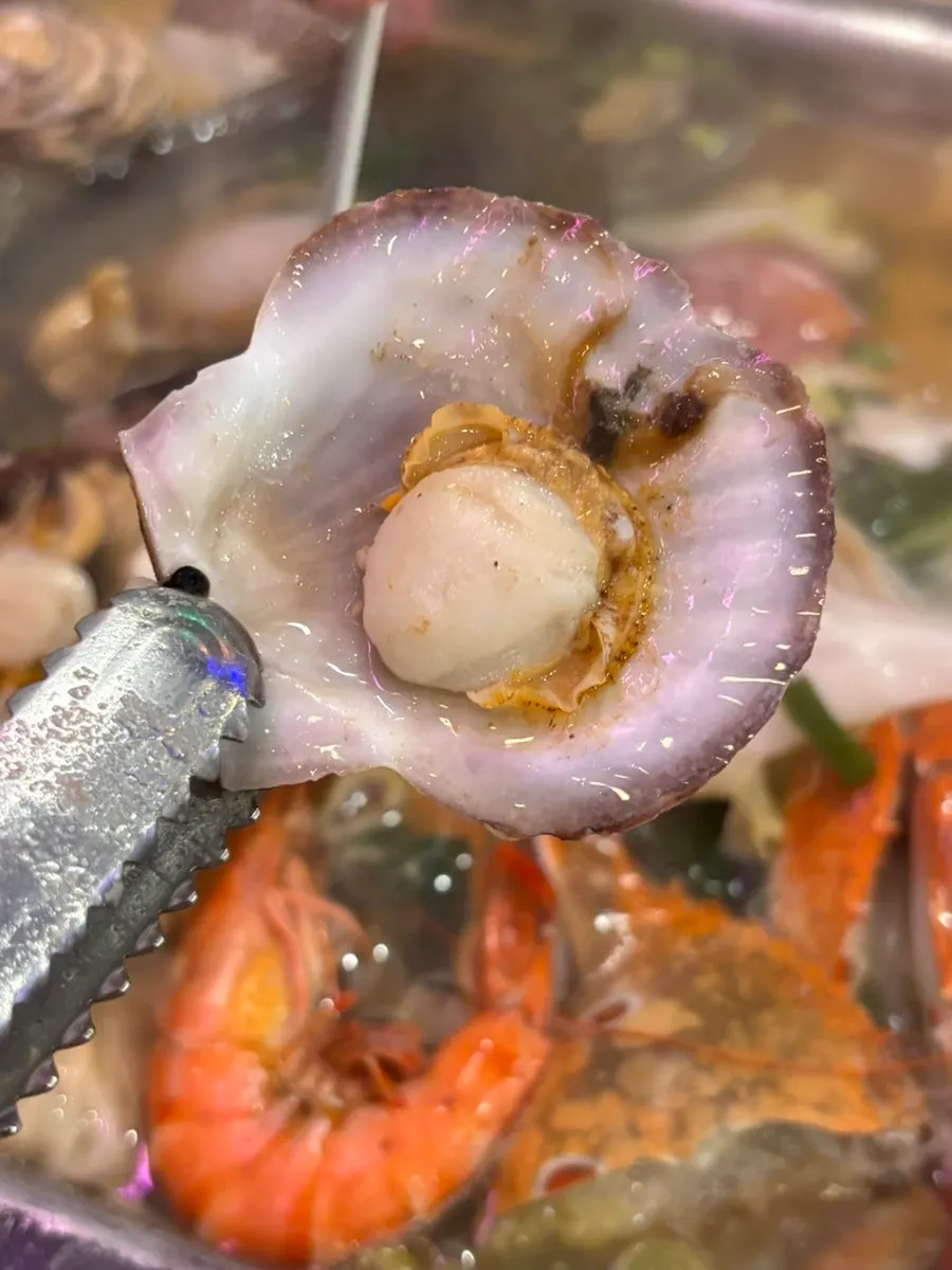 A bite of clam meat dipped in broth