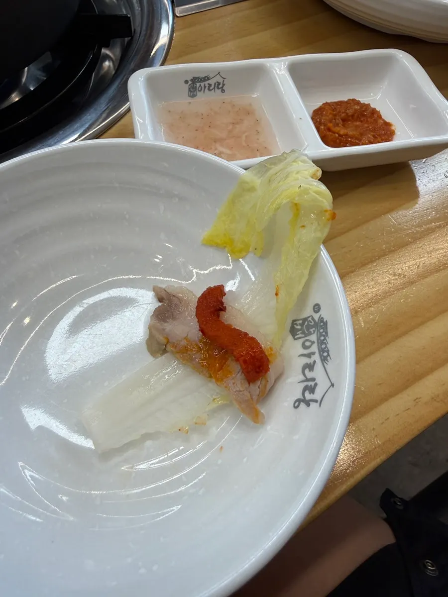 Bossam wrap topped with ssamjang and pickled radish strips