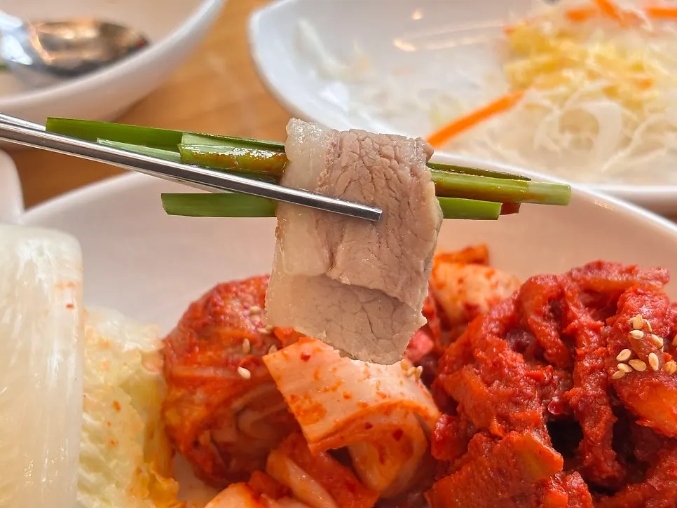 부추무침을 올린 보쌈 한 쌈