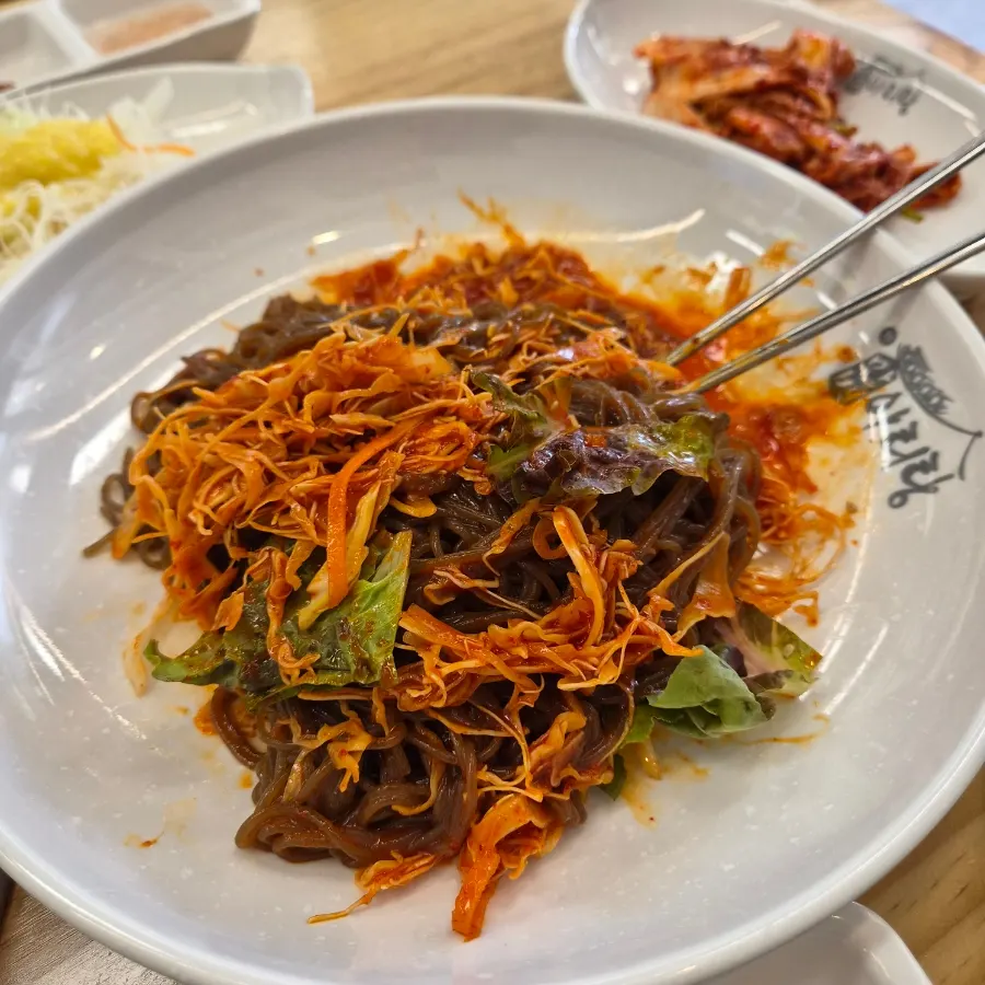 양배추채와 상추가 올라간 서비스 막국수