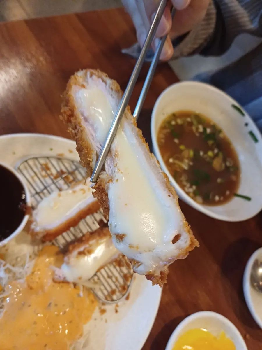 한 조각 집어든 치즈돈까스