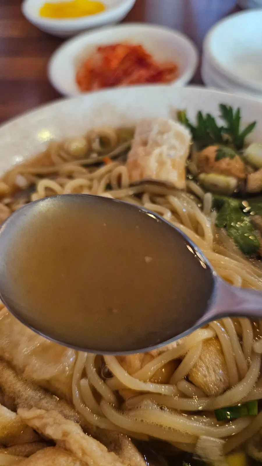A spoonful of fish cake udon broth
