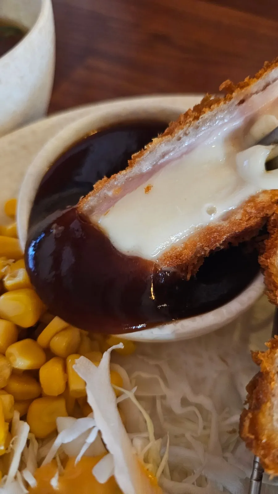 Cheese stretching long as it's lifted with chopsticks
