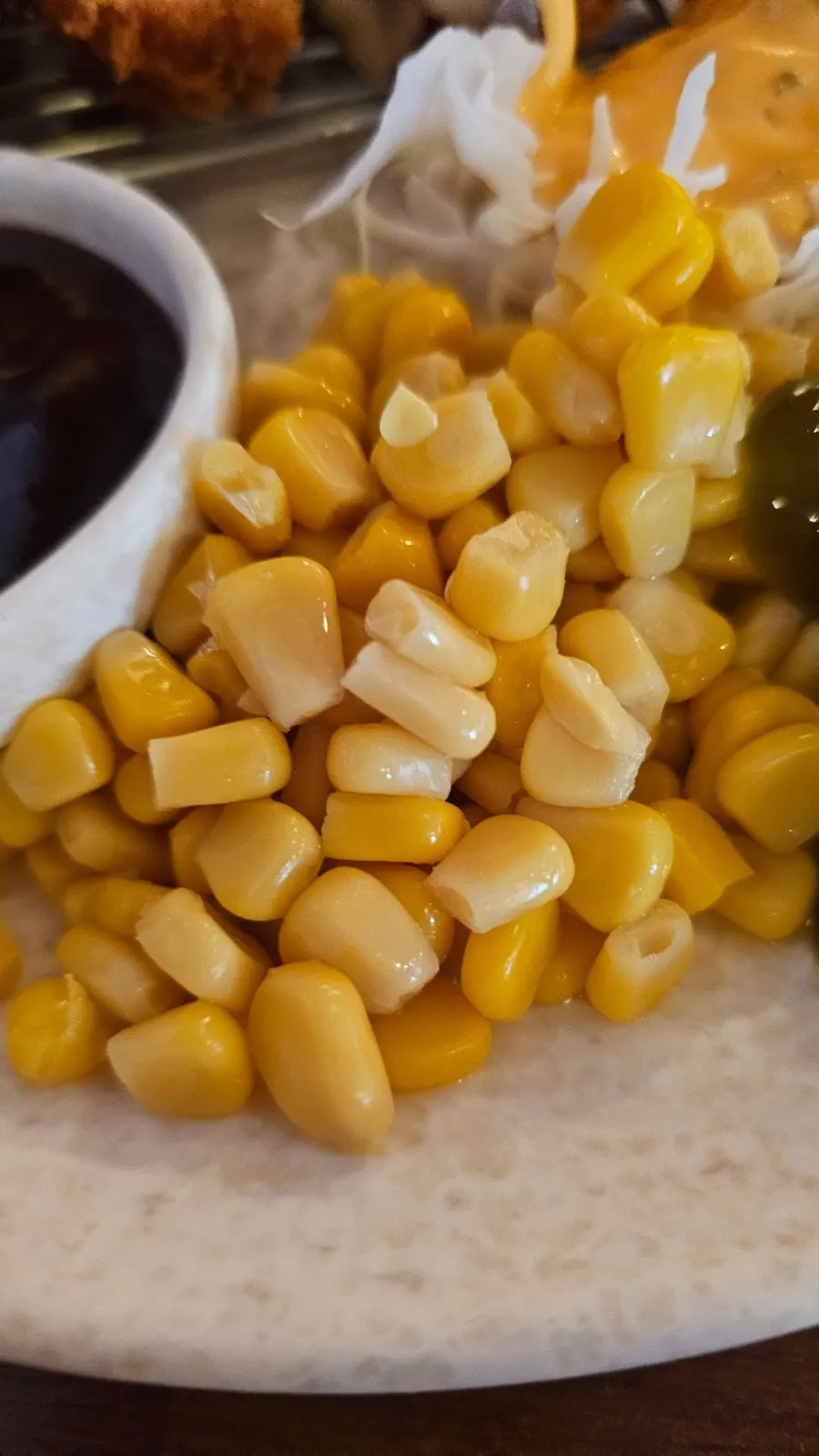 Cabbage salad, corn kernels, and jalapeños served as sides