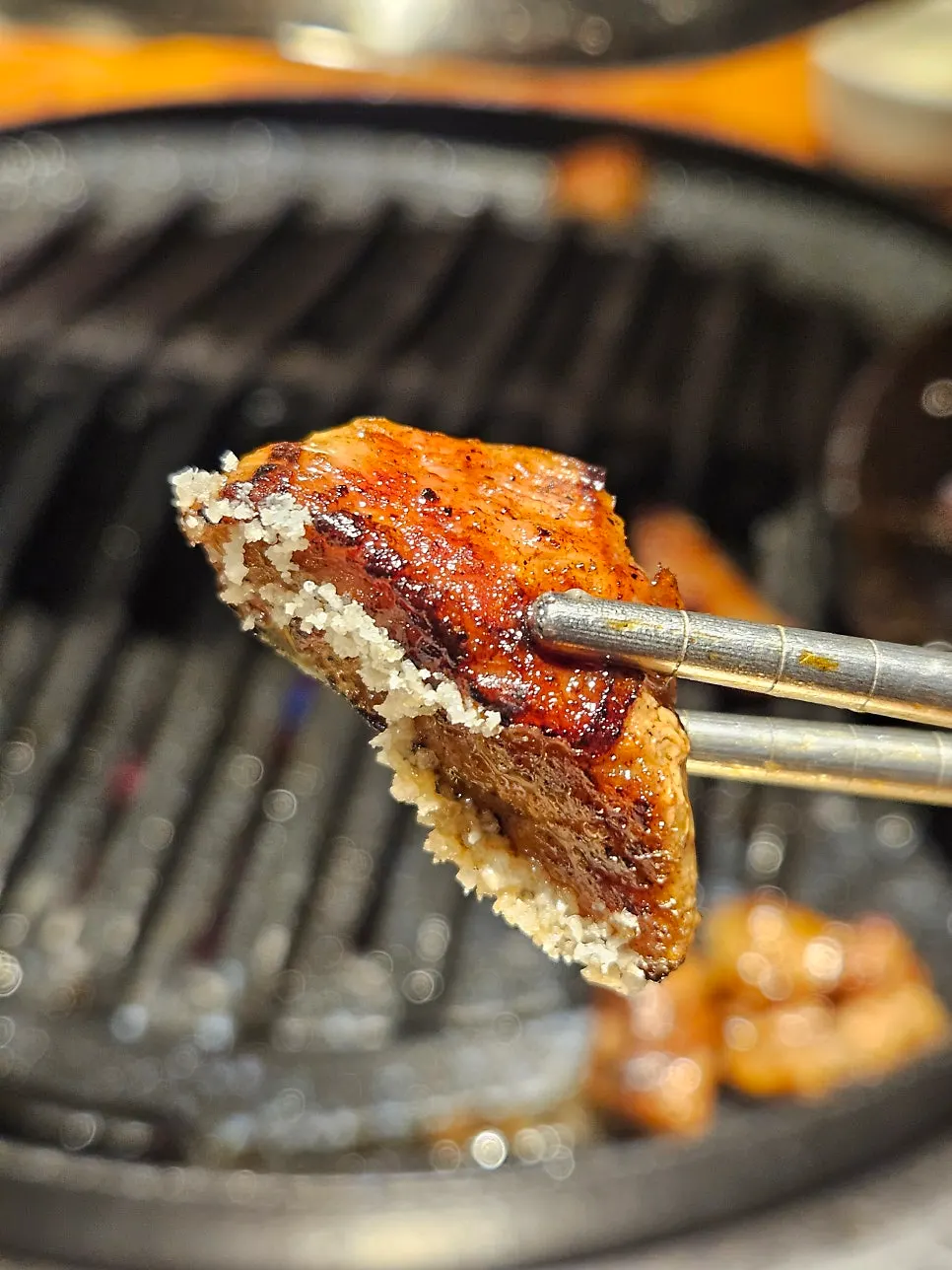 A grilled piece of meat topped with wild garlic leaves