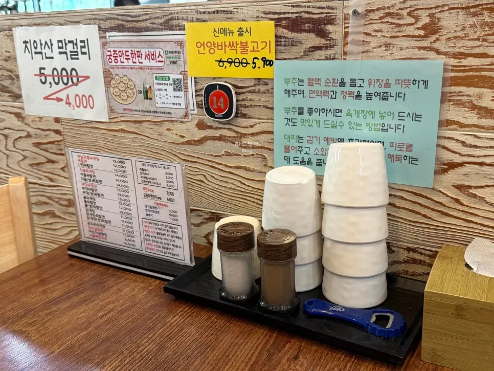 Water cups, condiments and a utensil holder on the table