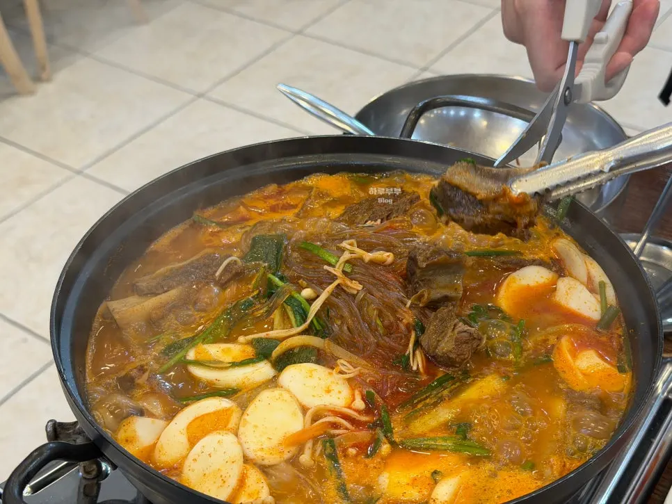 Cutting the braised short rib meat with scissors