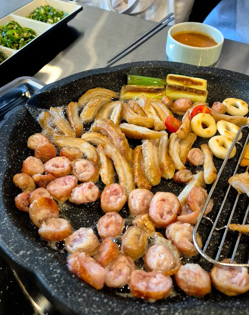 Par-grilled makchang cooking on the grill
