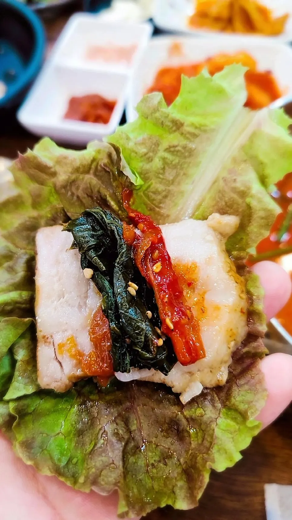 한방보쌈 고기를 김치에 싸 먹는 모습