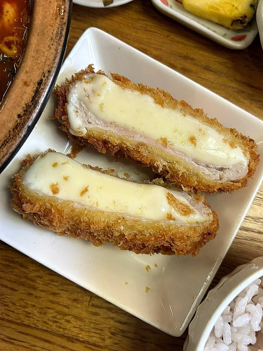 Melted mozzarella cheese stretching from the cheese katsu