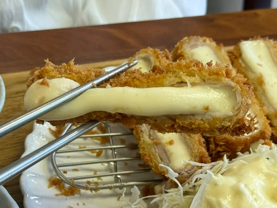 Cross-section of cheese katsu with stretchy melted cheese