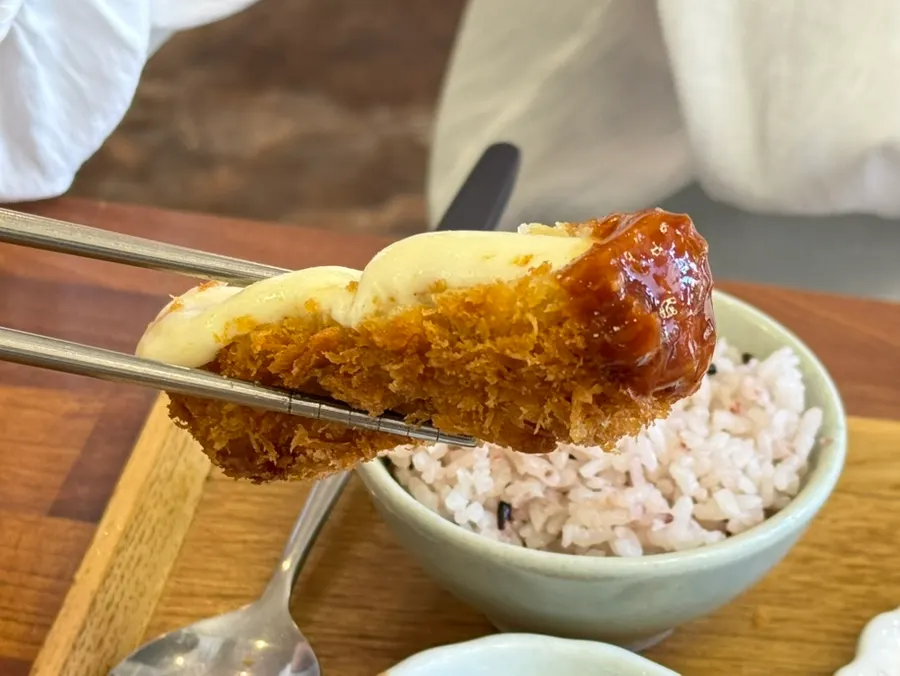 A piece of cheese katsu topped with wasabi