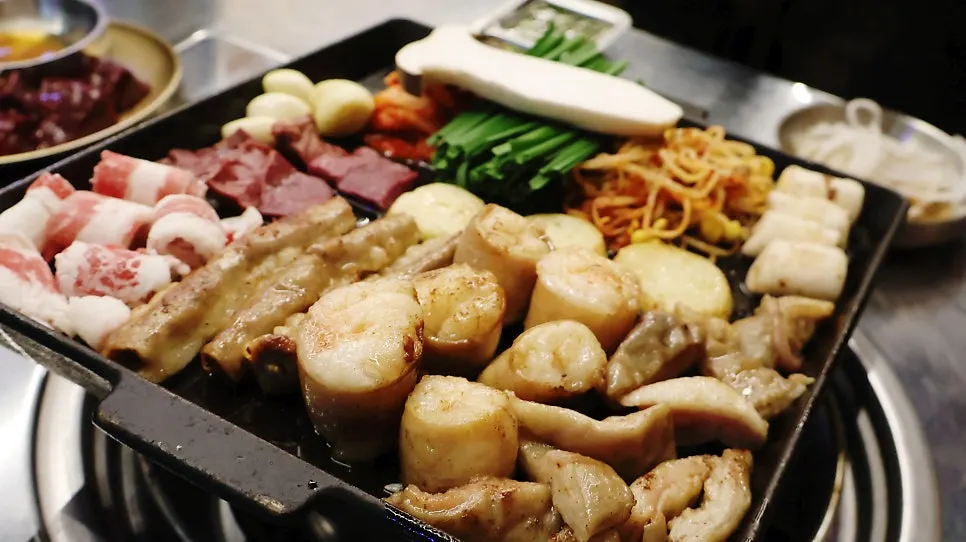 Mixed gopchang platter with chives and mushrooms on the hot plate