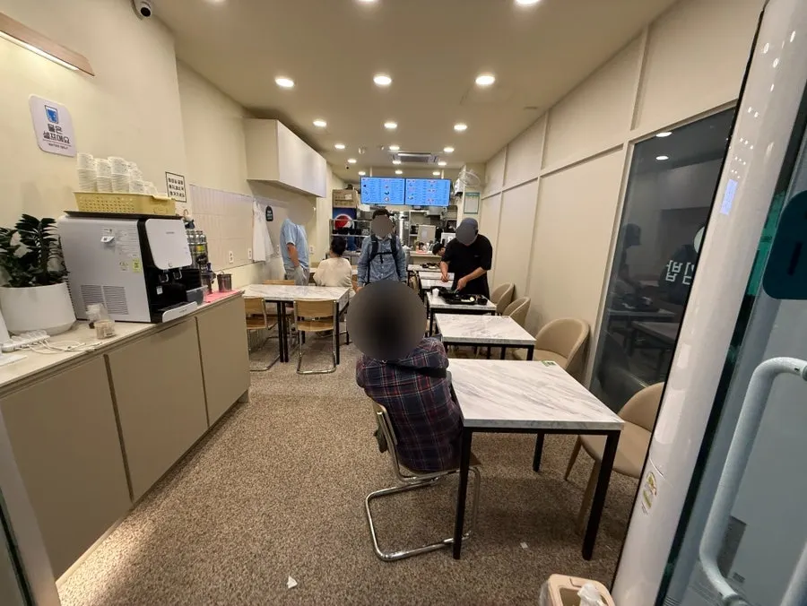 店內深處牆上的菜單板與桌位座席