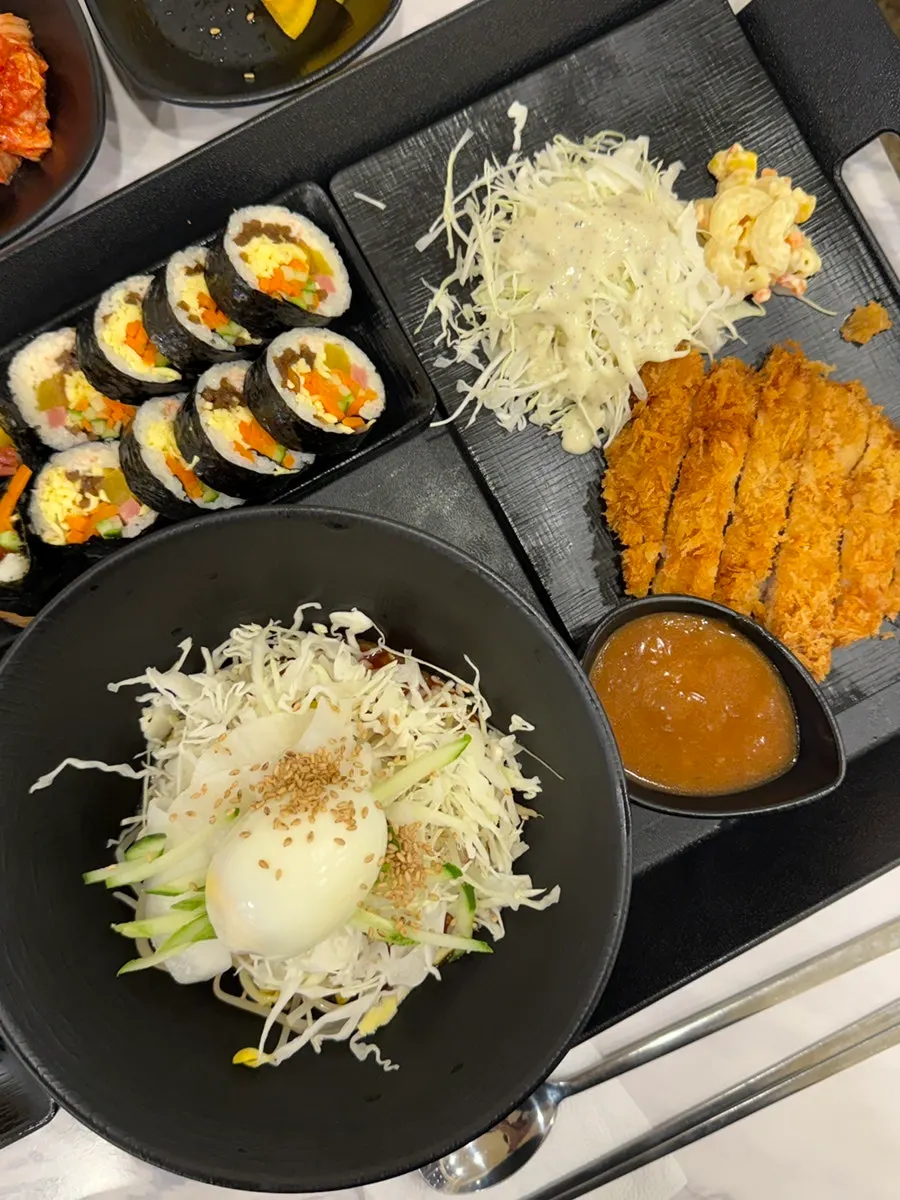 由辣拌麵、炸豬排、紫菜飯捲組成的涼拌辣拌麵套餐一桌菜