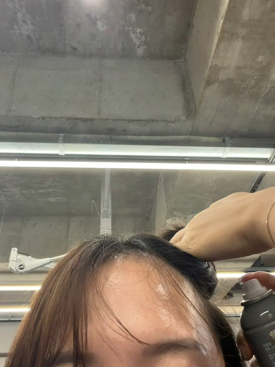 두피 보호 스프레이를 뿌리는 장면