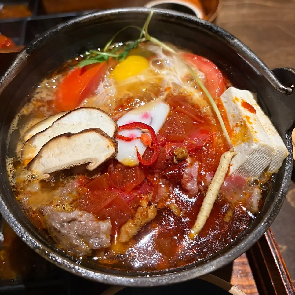Raw egg served with the spicy tomato hot pot