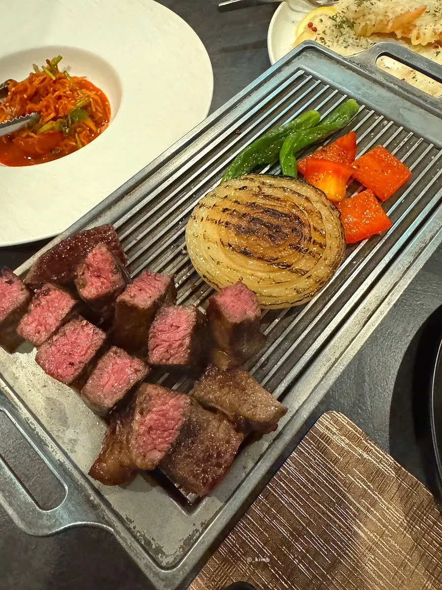 서버가 팬에 두툼한 한우를 굽는 모습