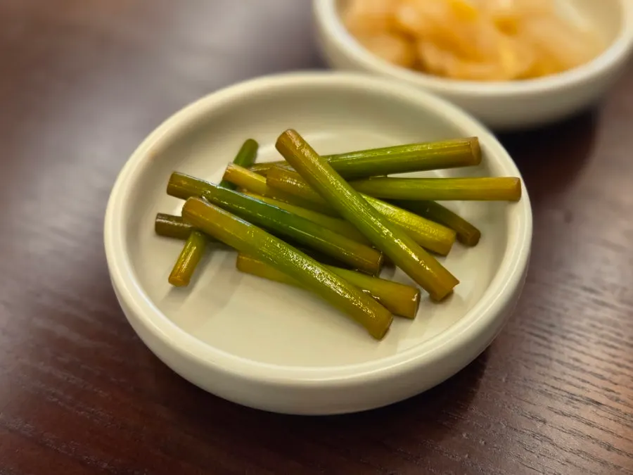 Basic banchan at Usul: white kimchi and pickled garlic scapes