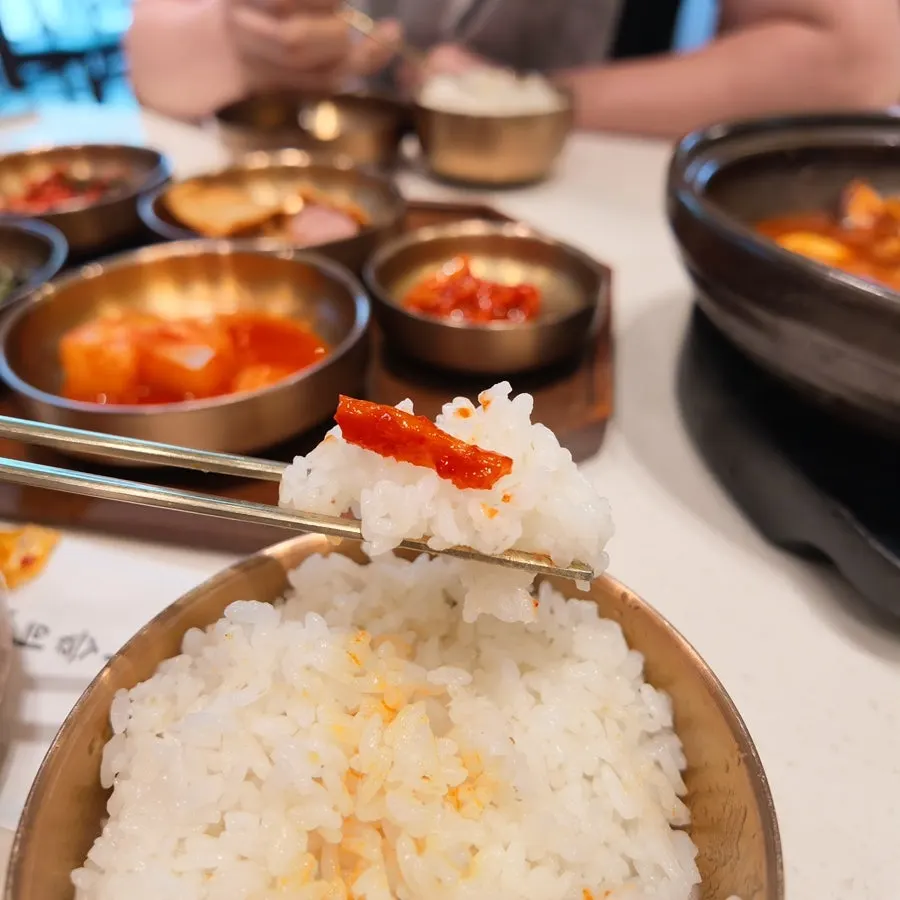 A piece of spicy beef short rib placed on a bowl of rice