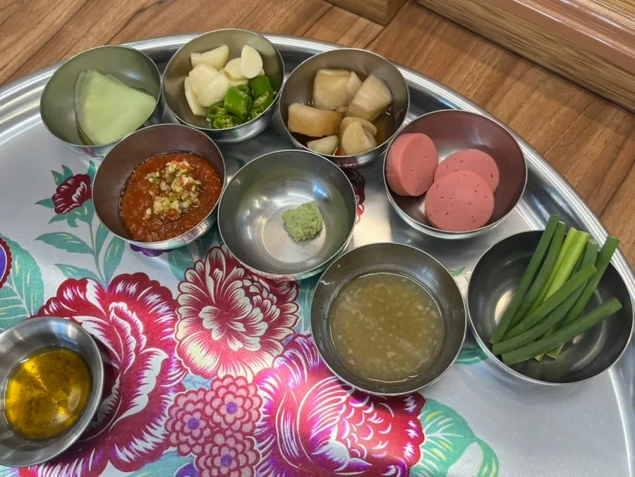 Table setting with garlic, chili, scallions and sauces