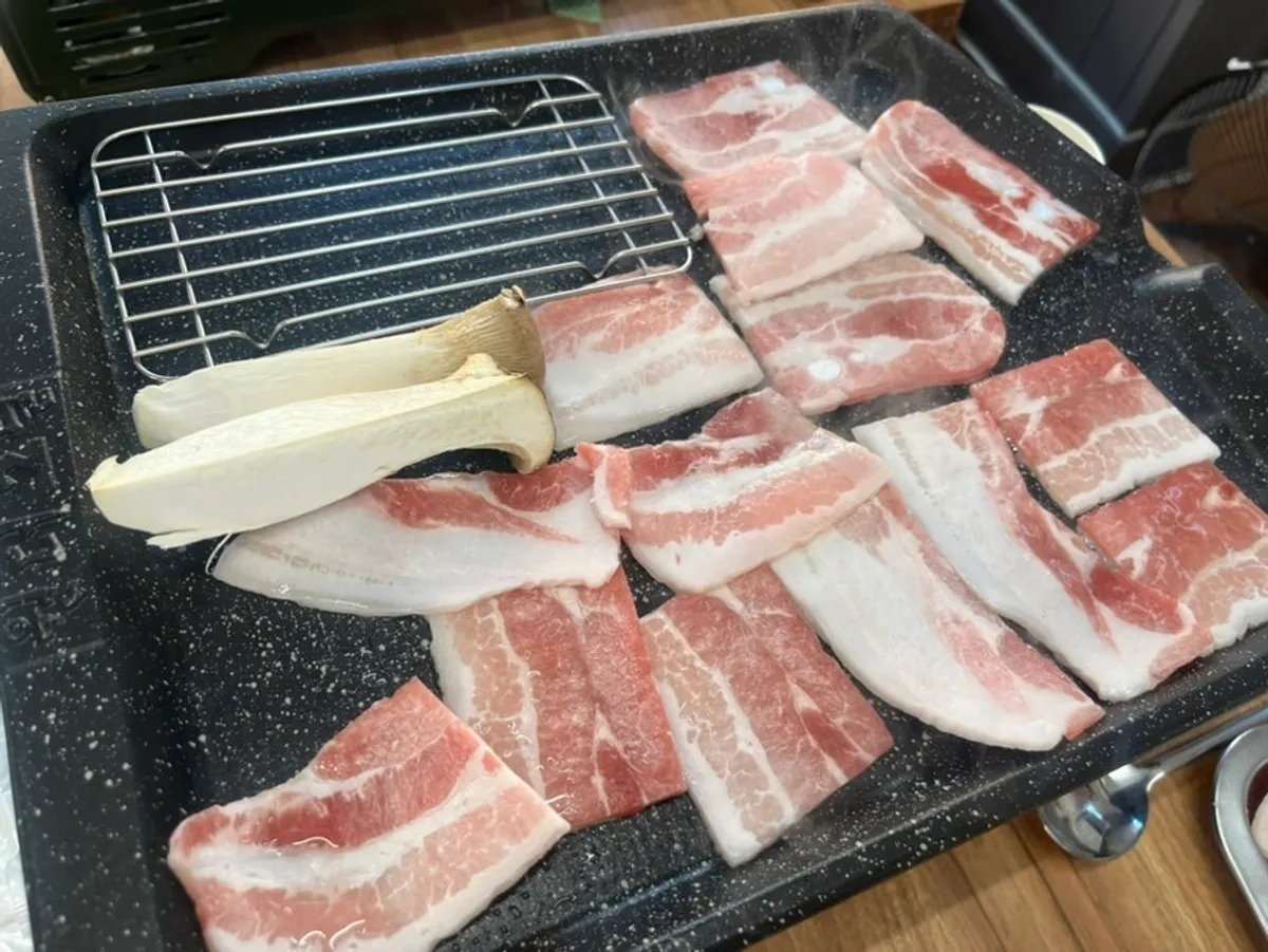 Three servings of frozen pork belly on the grill