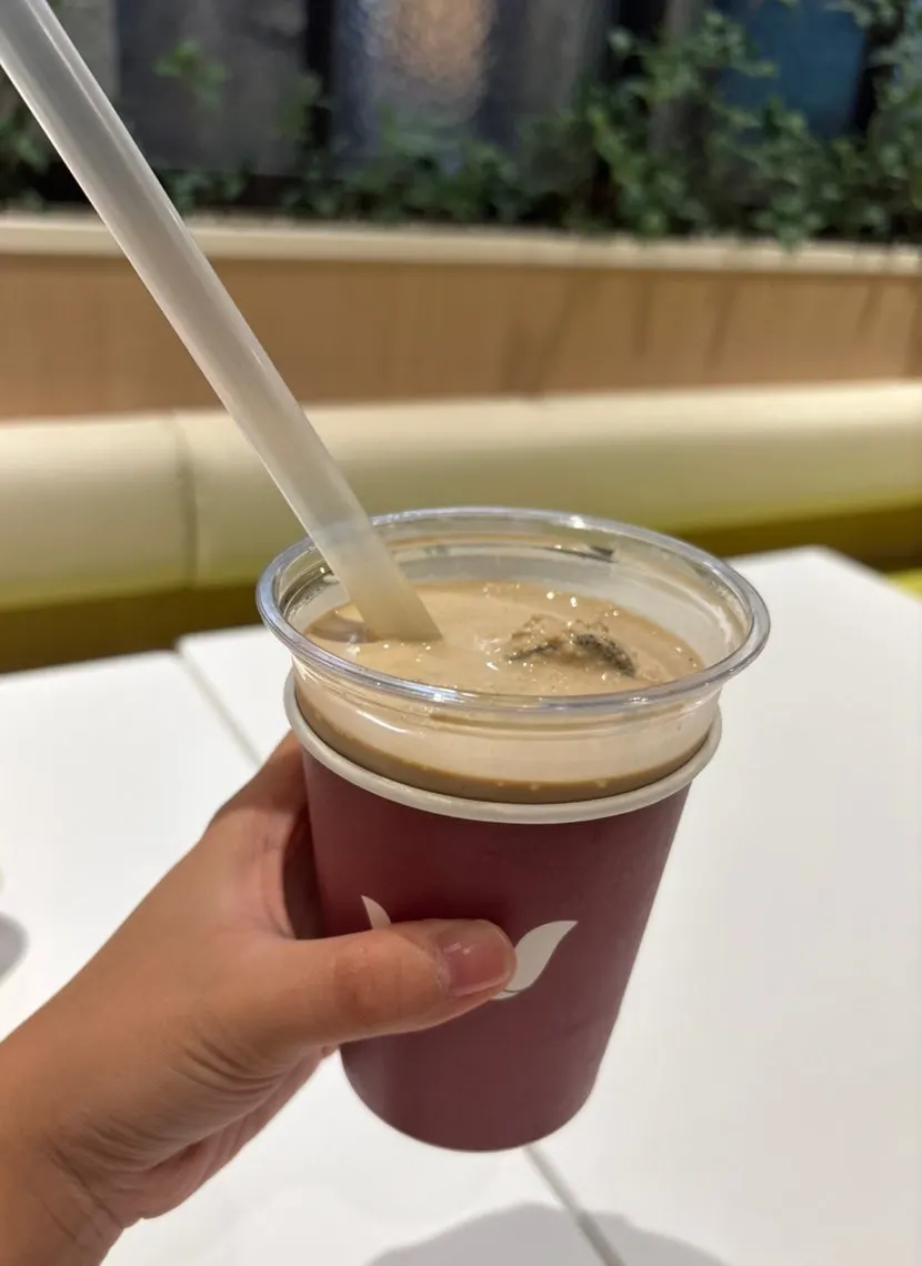 An ice cream latte glass with the ice cream half eaten