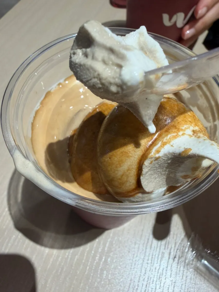 Scooping up vanilla ice cream and coffee with a spoon