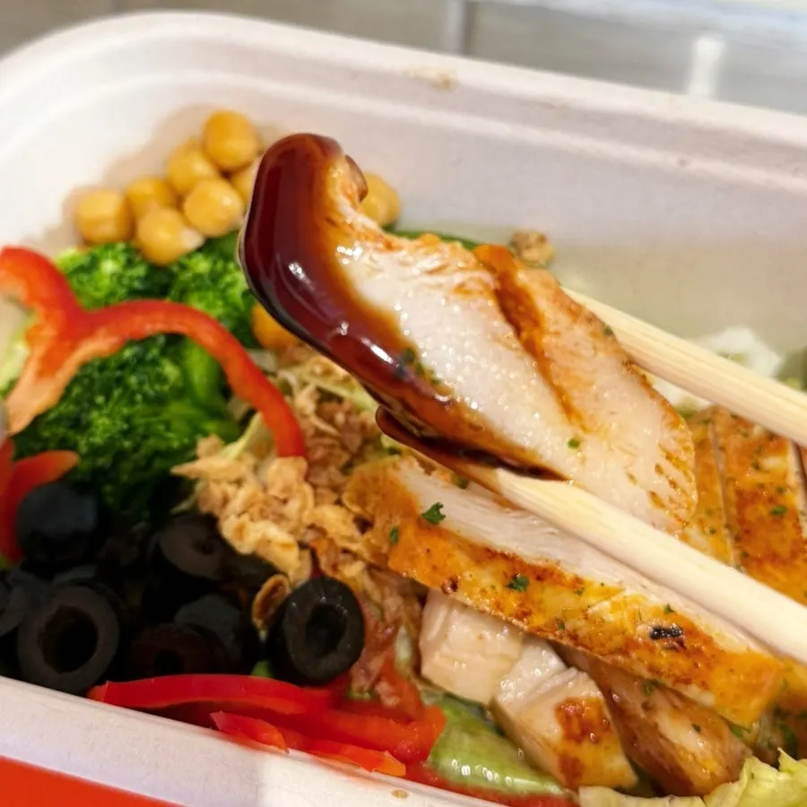 Dipping the salad into teriyaki sauce