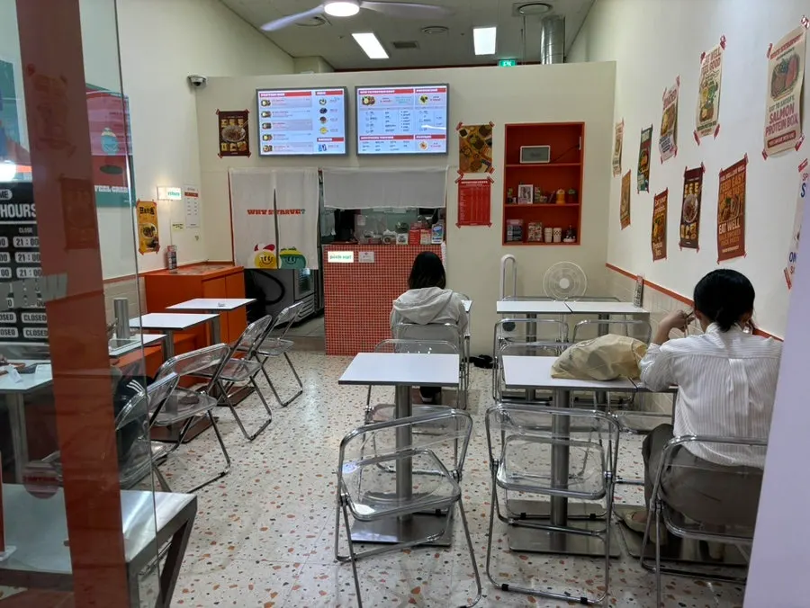 Storefront with orange sign and protein box photos