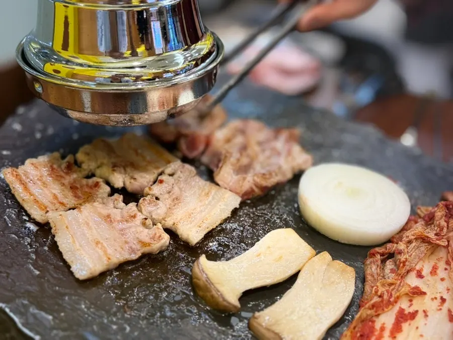 Samgyeopsal and kkodeulsal cooking on the grill