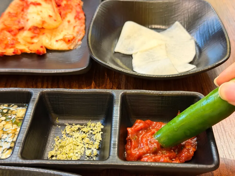 Small dishes of homemade ssamjang and secret yukjang sauce