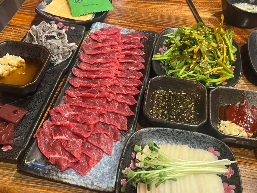Beef sashimi plated with pear and radish sprouts