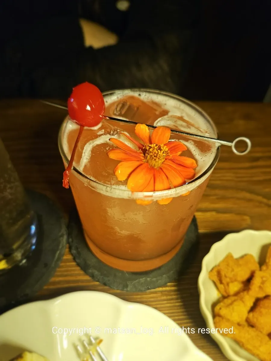 A cocktail topped with a cherry