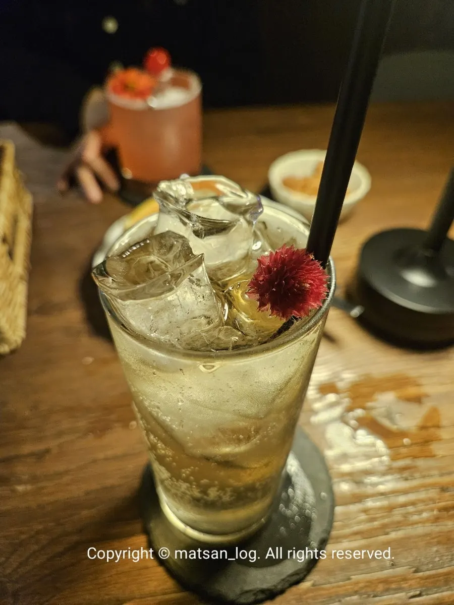 Yahwa cocktail topped with a whole flower