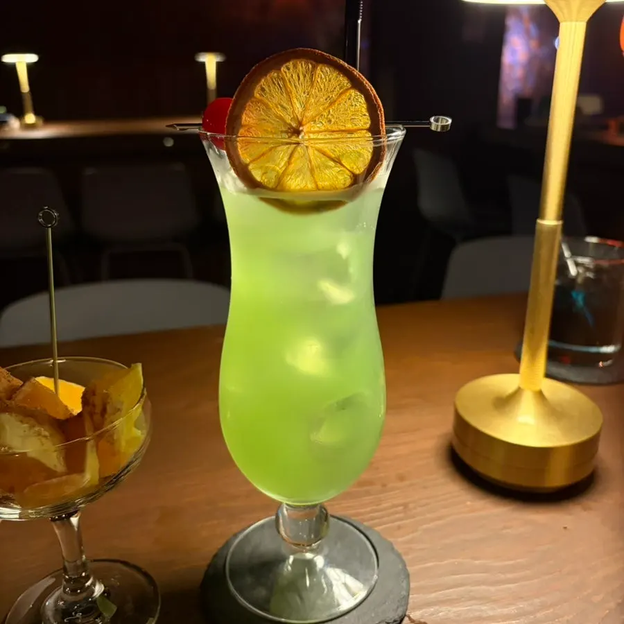 Bourbon cocktail topped with cherry and dried orange