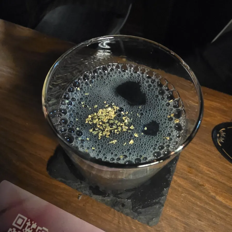 진한 남색과 금빛 가루가 보이는 별이 지는 밤 칵테일