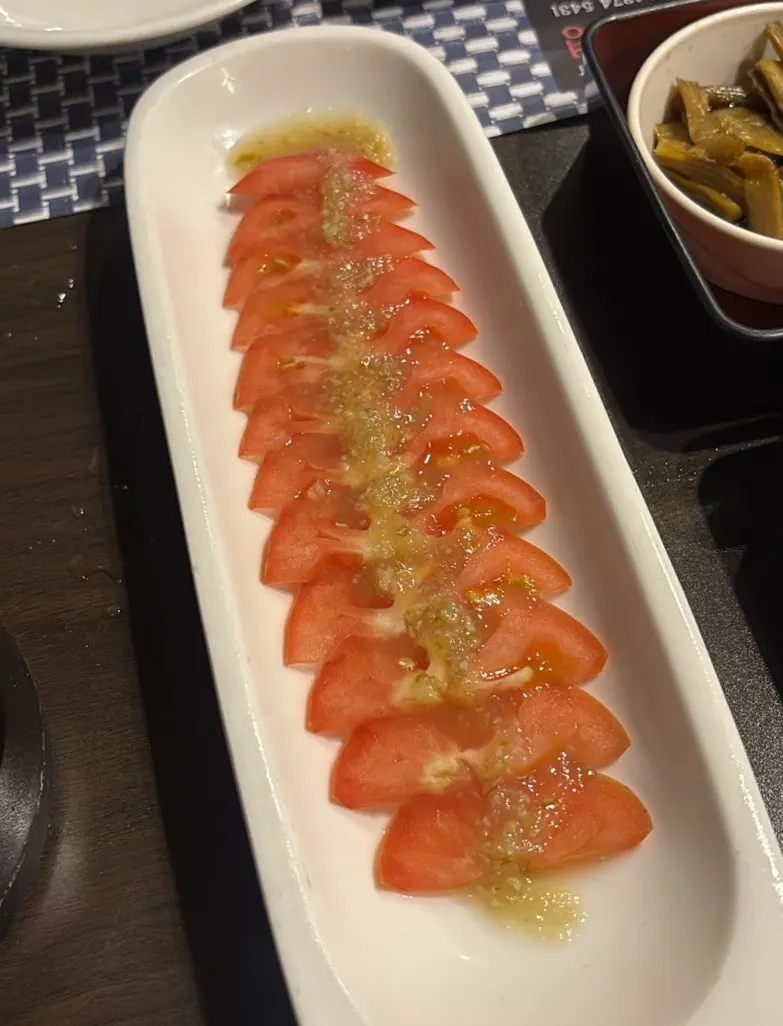 Tomato slices drizzled with yuzu sauce