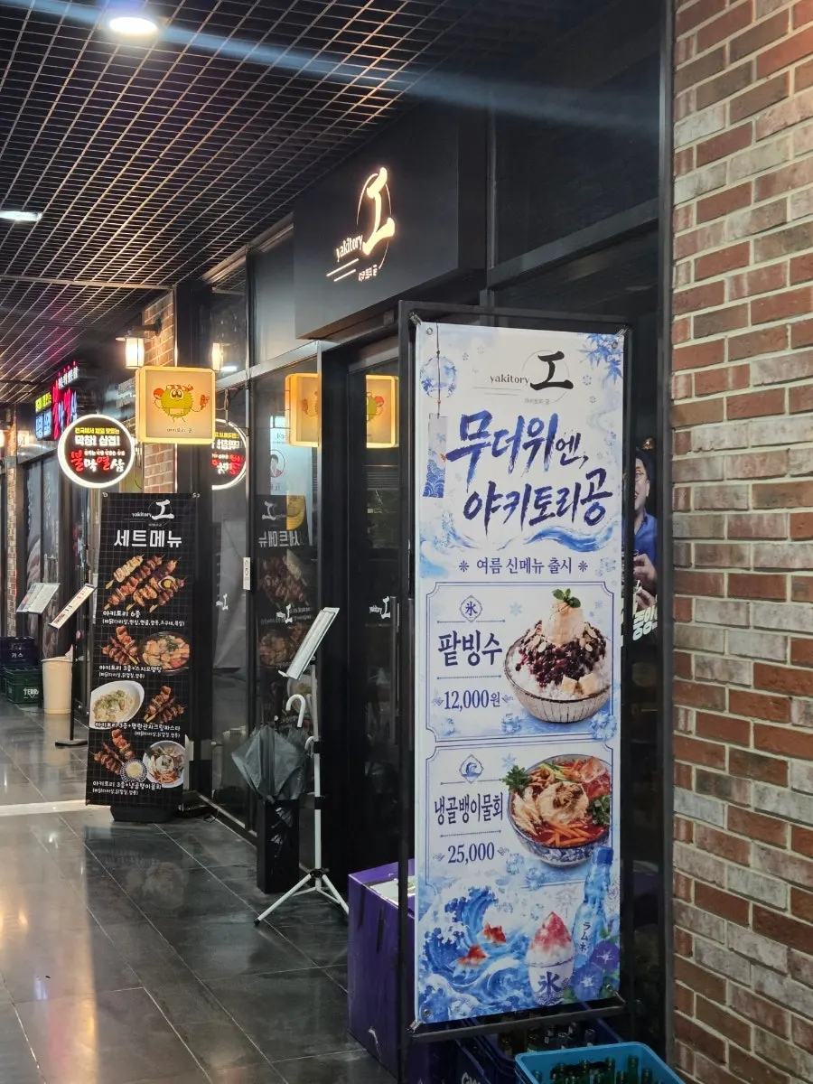 검정 바탕에 조명이 들어온 야키토리 공 외부 간판