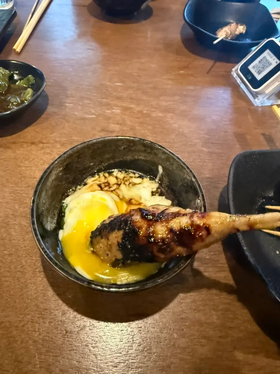 Soft-boiled egg and soy sauce on top of the tsukune