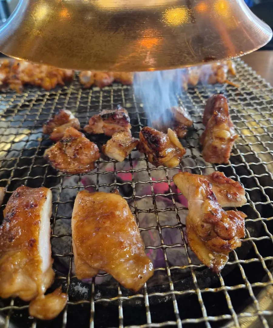 테이블 숯불 위에 올려진 초벌 닭갈비
