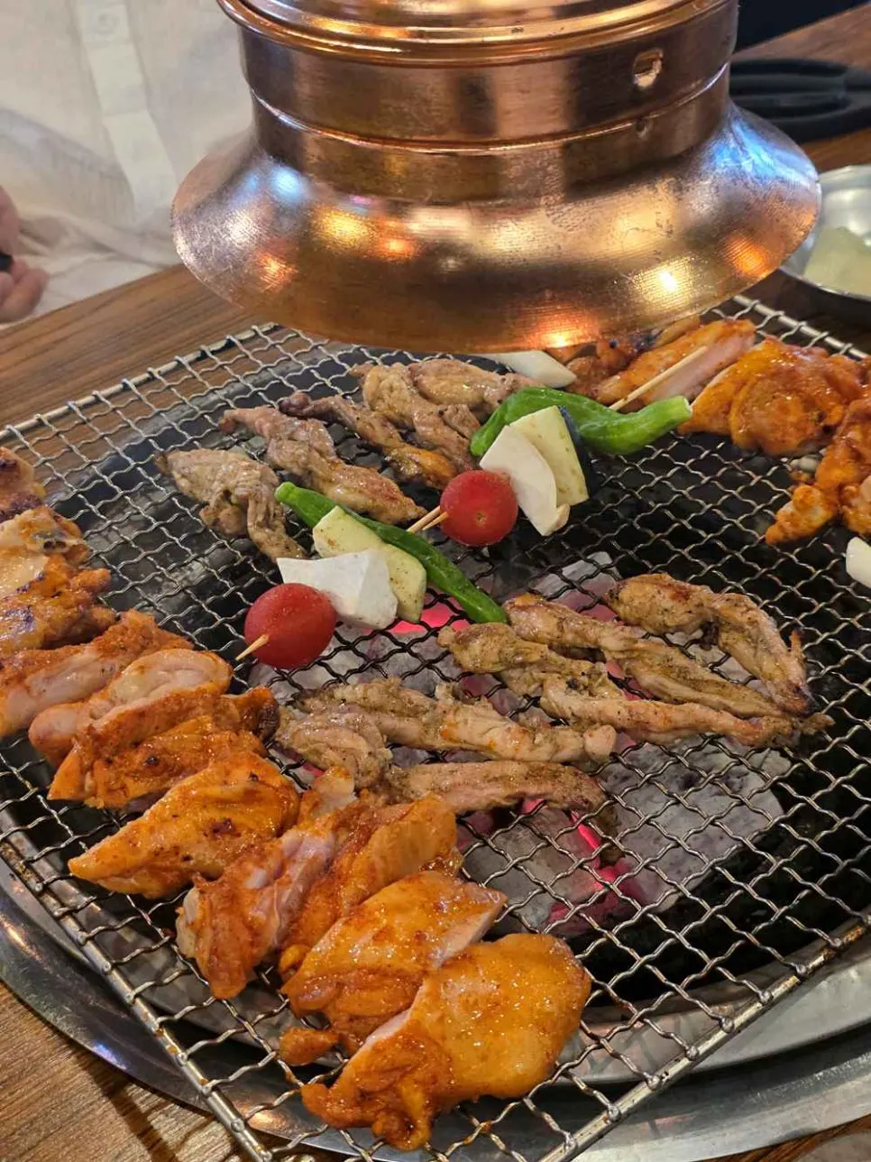 숯불 위에서 익기 시작한 초벌 닭갈비