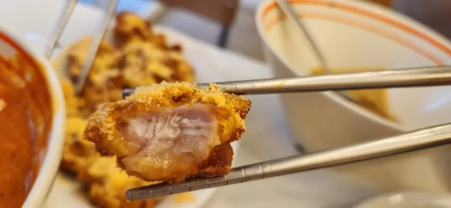 A piece of sundae picked up with chopsticks