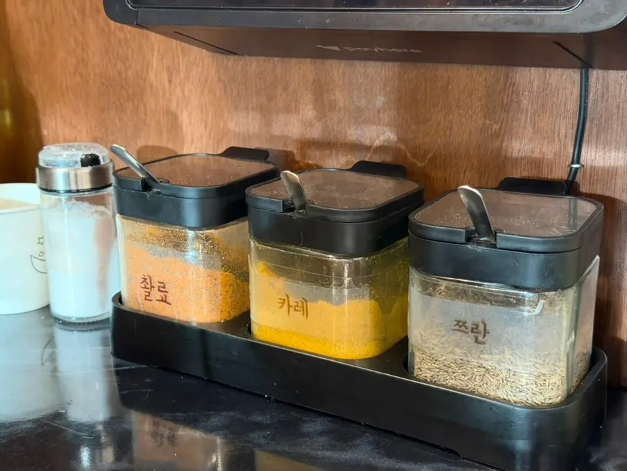 Cumin oil, curry powder and cumin powder sauces set on the table