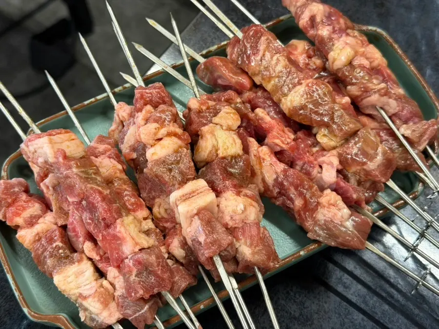 Plump raw lamb skewers before grilling