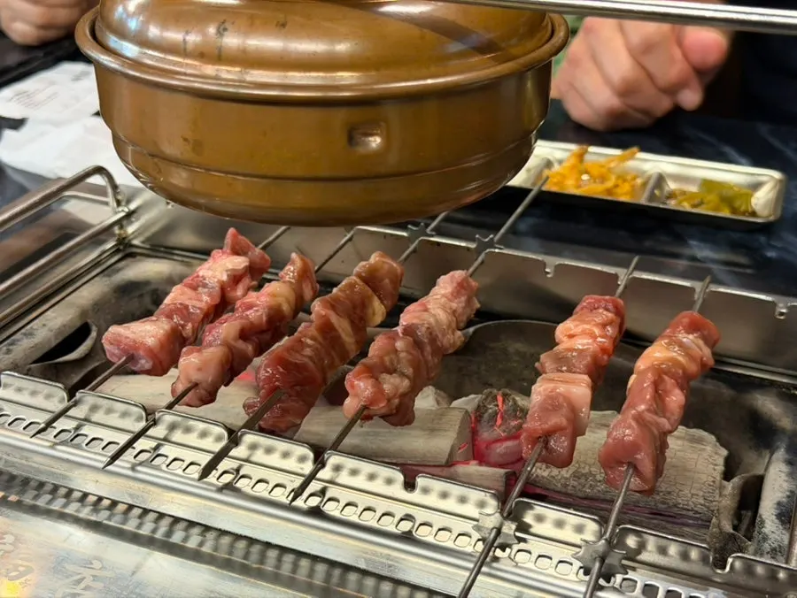 Skewers placed on the charcoal grill starting to cook
